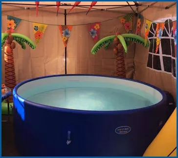 Inflatable hot tub in a colourful tropical party setup