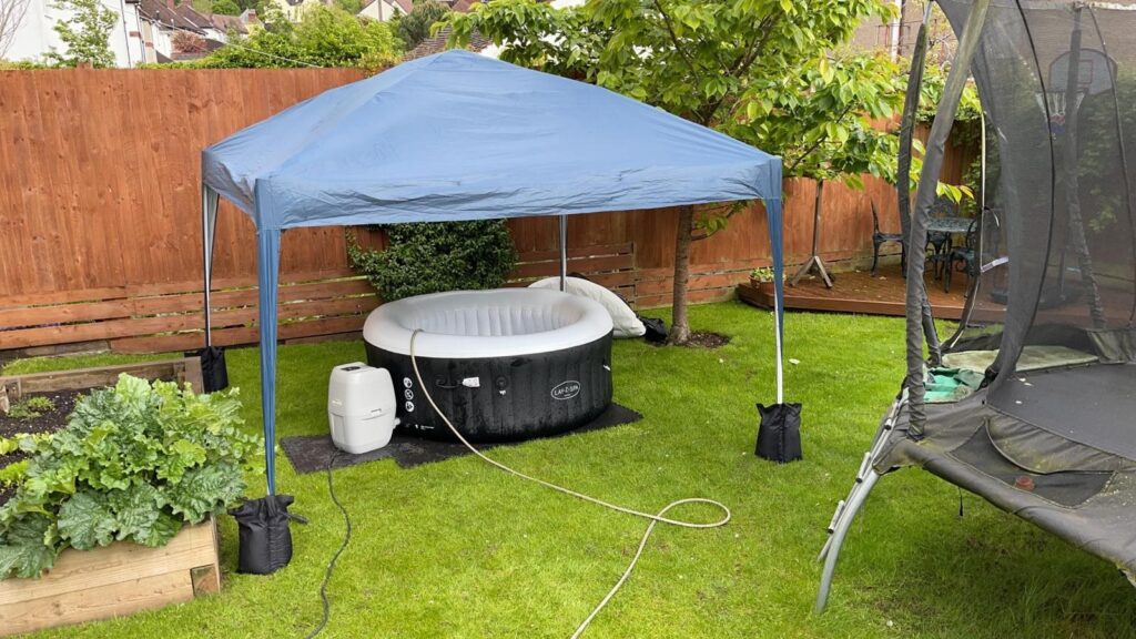 Covered Lay-Z-Spa hot tub setup in a family garden
